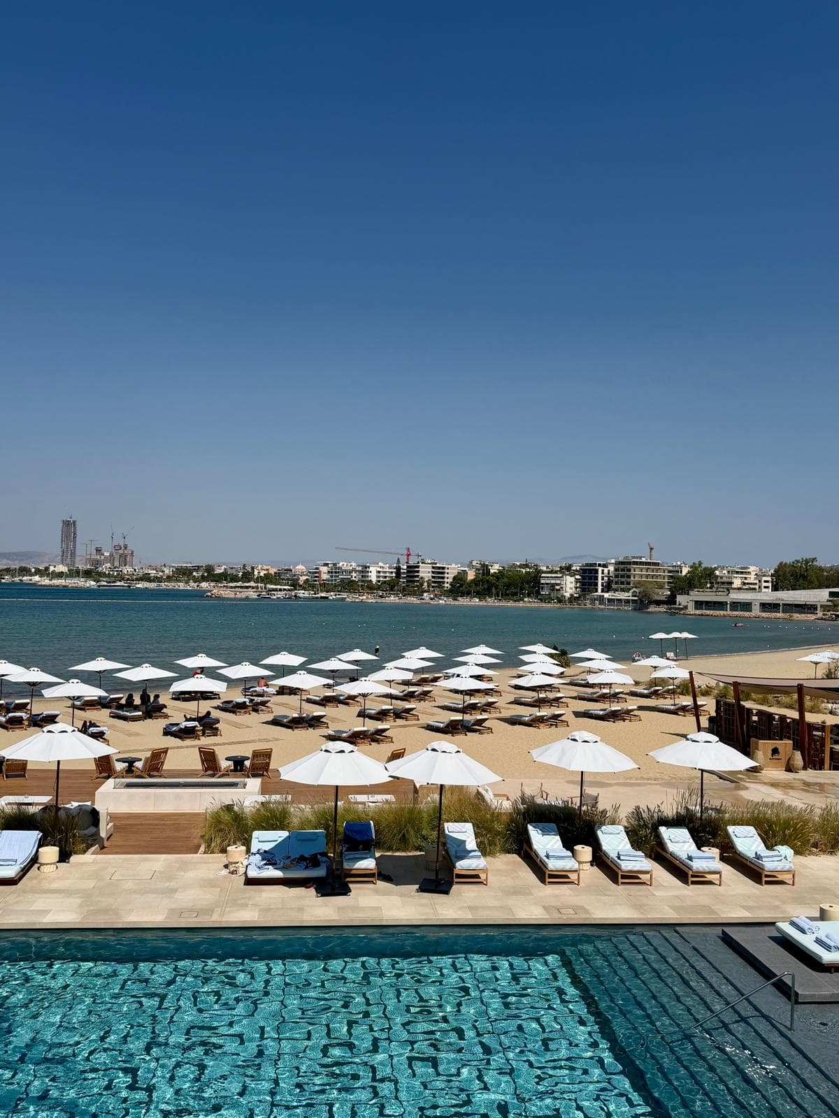 Beach club with white umbrellas beside a pool